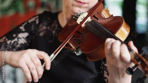 a woman aged musician plays the violin