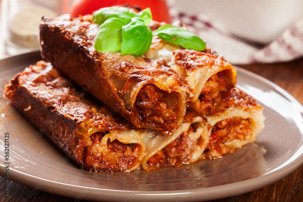 Baked cannelloni with minced meat and bechamel sauce on a plate Baked cannelloni with minced meat and bechamel sauce on a plate