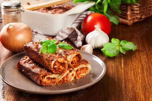 Photos Baked cannelloni with minced meat and bechamel sauce on a plate