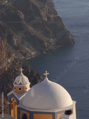Catholic Church of St. Stylianos Fira Santorini island  Greece. View of the historical part of the town of Fira  the mountains and the sea during sunset.