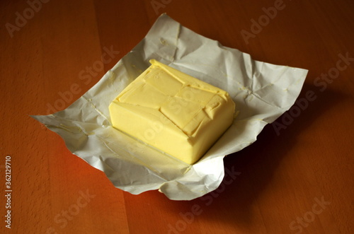 Opened Butter Package on wooden table. Butter Prices are at a record high. Cooking concept.  