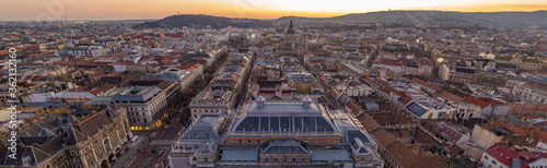 Panorama aerial drone shot of St. Stephen's Basilica over opera house in Budapest sunrise morning glow