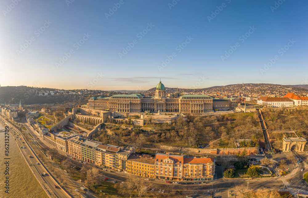 Aerial drone shot of Buda Castle palace facade on hill in Budapest sunrise glow