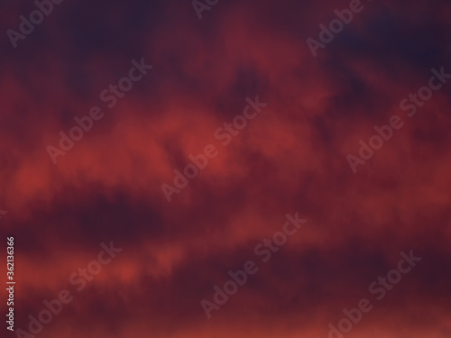 Red dramatic evening сumulus clouds in the sky. Colorful cloudy sky at sunset. Sky texture, abstract nature background