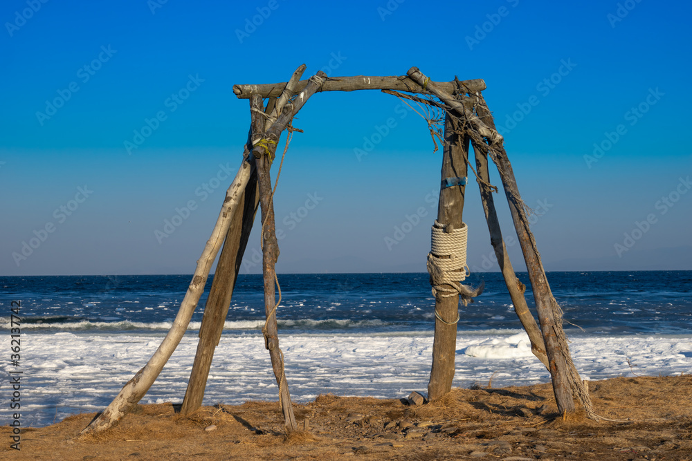 Wooden swing on the background of the sea in winter Wooden swing on the background of the sea in winter