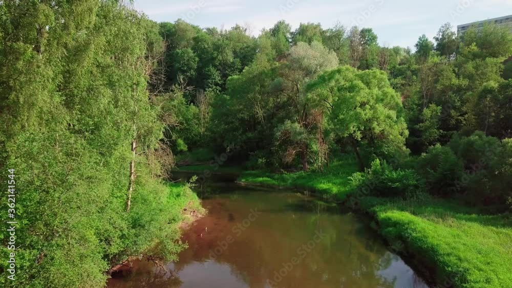 Flight over the River forest at sunset. Summer landscape of nature of Russia. With Tree trunks growing on banks. Moscow Region, Istra River. Fly drone. 4K resolution Flight over the River forest at sunset. Summer landscape of nature of Russia. With Tree trunks growing on banks. Moscow Region, Istra River. Fly drone. 4K resolution