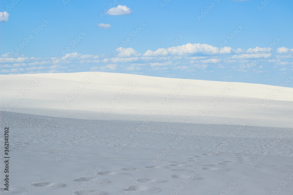 desert of white sand under an open sky with clouds