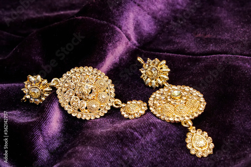 Close up portrait jewellery earrings on purple/magenta colour fabric