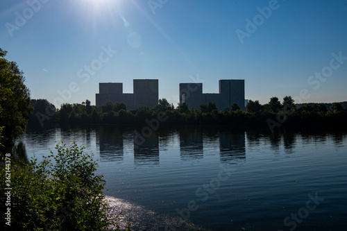 Fototapeta modern houses by the lake appear in the water at dawn