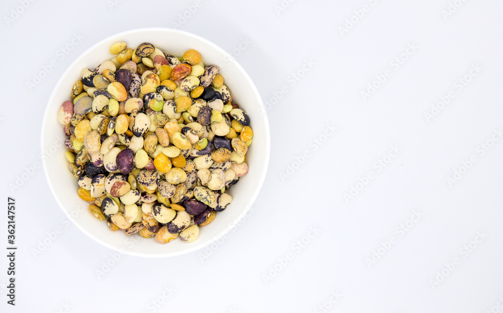 Colorful kidney bean in white ceramic bowl top view. Healthy food banner template with text place. Kidney bean ornament Colorful kidney bean in white ceramic bowl top view. Healthy food banner template with text place. Kidney bean ornament