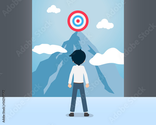 Salary man looking at the target on a high mountain from below
