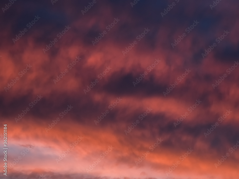 Red dramatic evening сumulus clouds in the sky. Colorful cloudy sky at sunset. Sky texture, abstract nature background
