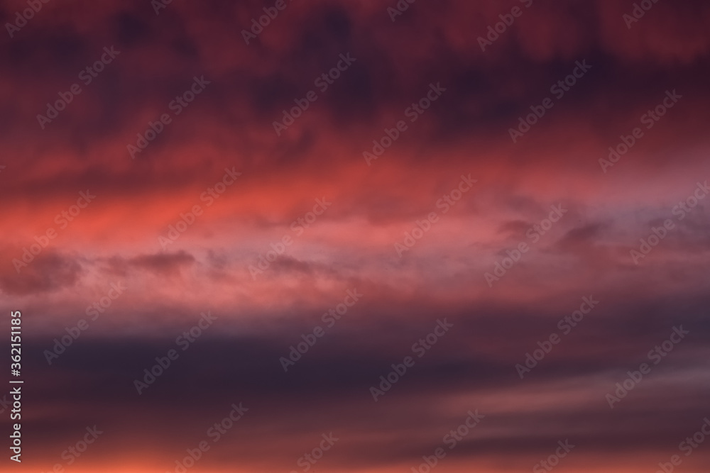 Red dramatic evening сumulus clouds in the sky. Colorful cloudy sky at sunset. Sky texture, abstract nature background