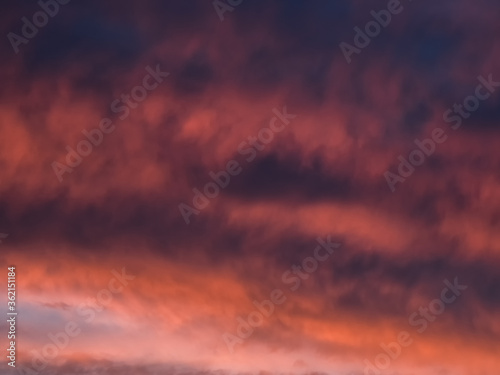 Red dramatic evening сumulus clouds in the sky. Colorful cloudy sky at sunset. Sky texture, abstract nature background