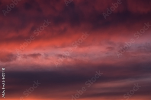 Red dramatic evening сumulus clouds in the sky. Colorful cloudy sky at sunset. Sky texture, abstract nature background © sablinstanislav