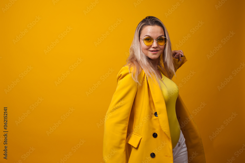 Stylish positive young woman on yellow background, copy space. Stylish positive young woman on yellow background, copy space.