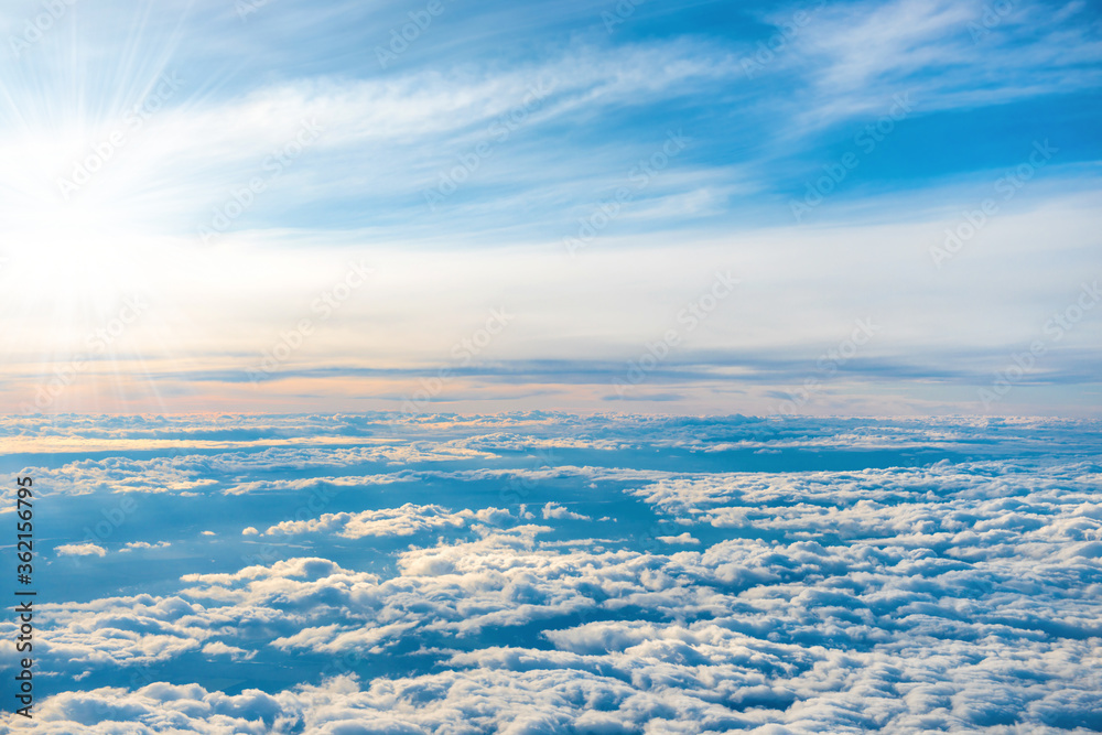 Aerial view of blue sky with layers of white fluffy cumulus and cirrus clouds