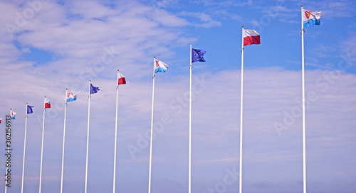 Gdynia, Poland - June 21, 2020. Flags of Europe, Poland and Gdynia against blue sky. Gdynia seaport.