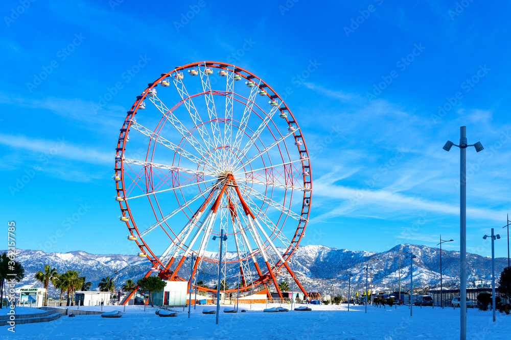 Batumi, Adjara, Georgia - 12.03.2020 : Ferris Wheel of Batumi against Georgia`s Black Sea and Blue Sky, Batumi, Adjara, Georgia, in the snow day of winter