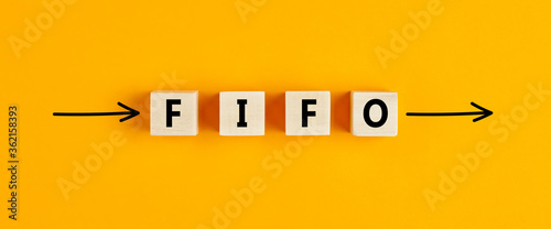 The business abbreviation fifo (first in first out) written on wooden blocks with directional arrows photo