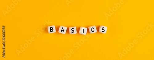 Basics word written on wood blocks on yellow background with flat lay view photo