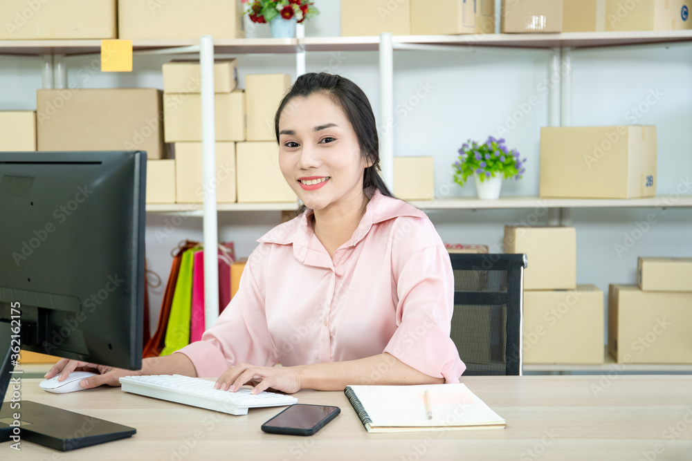Online merchandise seller packing and preparing a packages in her workplace for shipment to customers. Woman relaxing and stretching herself after working for a longtime. ecommerce merchandise concept Online merchandise seller packing and preparing a packages in her workplace for shipment to customers. Woman relaxing and stretching herself after working for a longtime. ecommerce merchandise concept