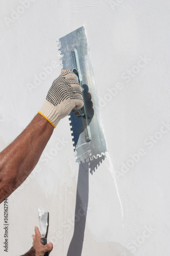 Obraz na płótnie Builder using plastering tool for finishing wall and floor.