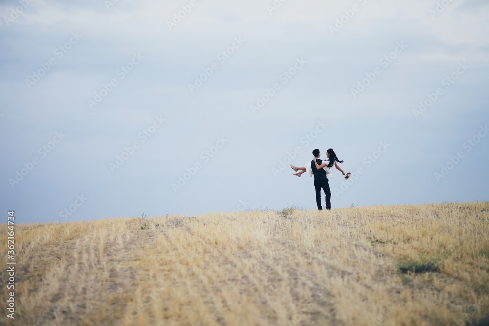 The bride and groom hold hands, hug each other and walk in the park. wedding The bride and groom hold hands, hug each other and walk in the park. wedding