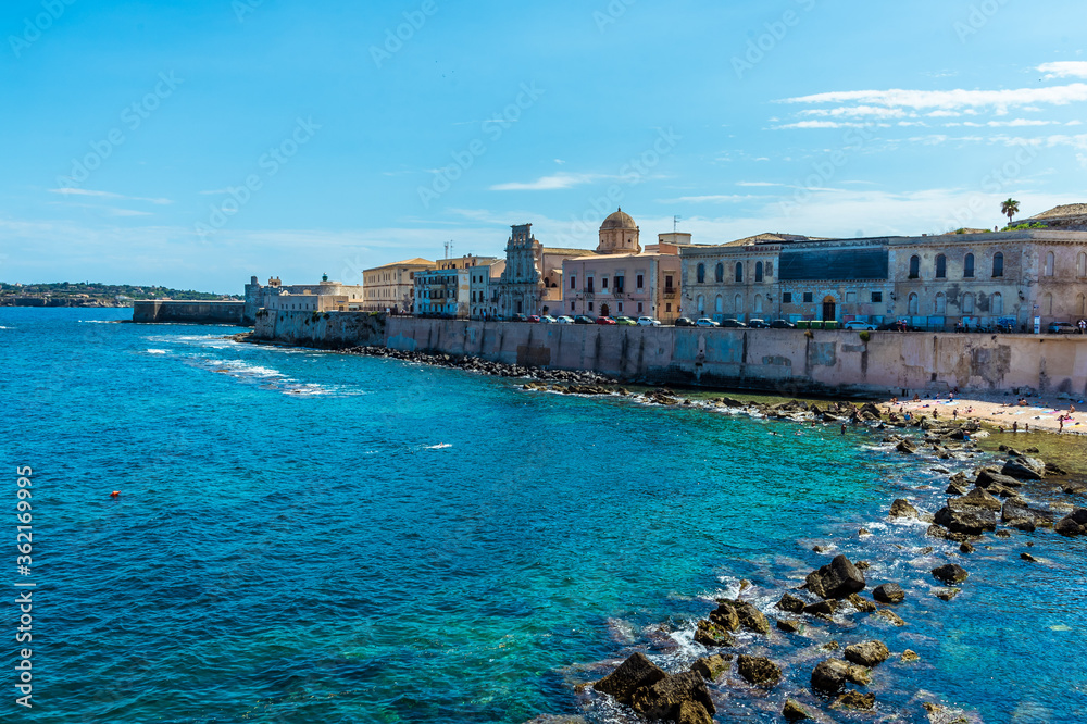 A view along the shoreline towards Castello Maniace on Ortygia island in Syracuse, Sicily in summer