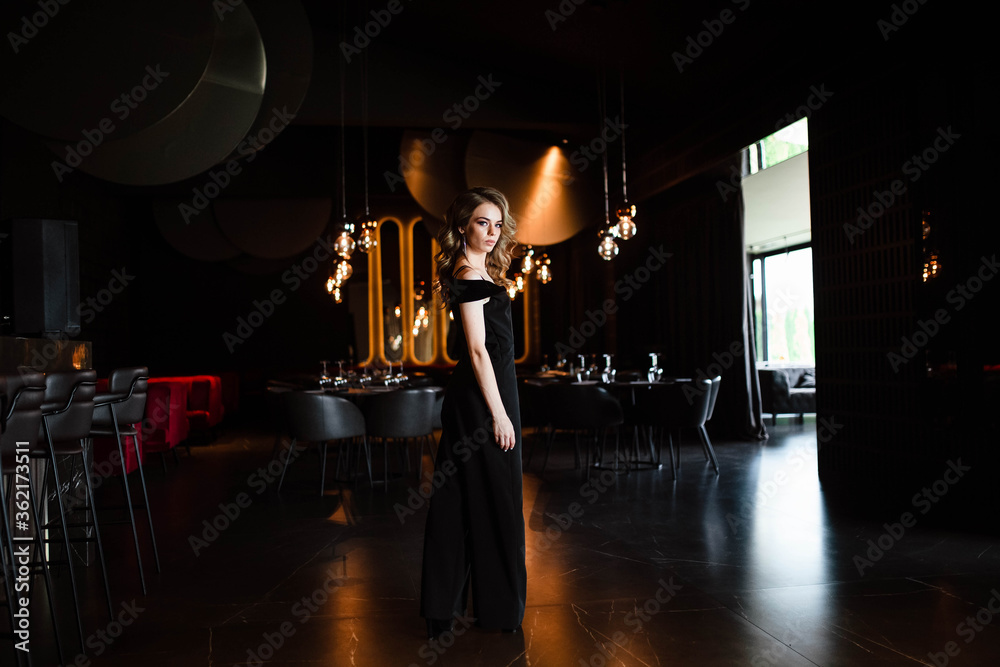 Beautiful blonde, young girl. Portrait of a young girl in a restaurant. Young girl in a restaurant on a black background. Portrait of a girl in a black dress. Young girl. Beautiful blonde, young girl. Portrait of a young girl in a restaurant. Young girl in a restaurant on a black background. Portrait of a girl in a black dress. Young girl.