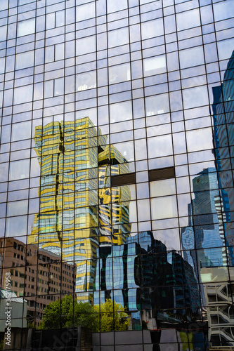 Reflet abstrait d'immeuble sur façade d'immeuble en verre. Effet de distorsion sur miroir.