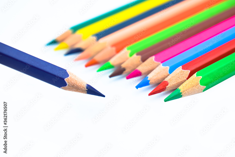 Line of different colored wood pencil crayons pointing at a purple color pencil Line of different colored wood pencil crayons pointing at a purple color pencil