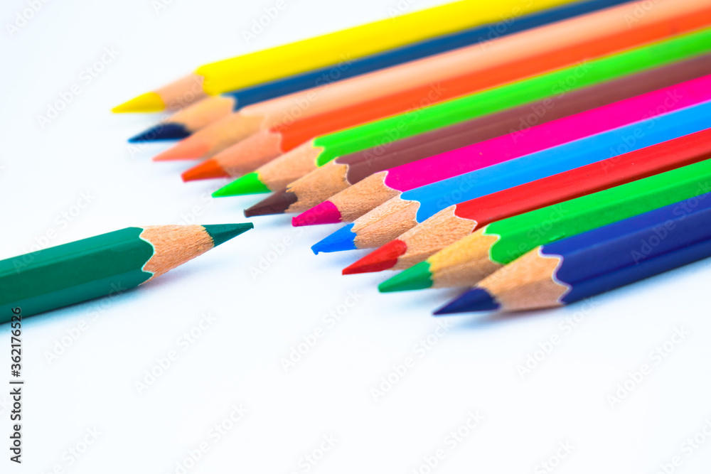 Line of different colored wood pencil crayons pointing at a blue color pencil Line of different colored wood pencil crayons pointing at a blue color pencil