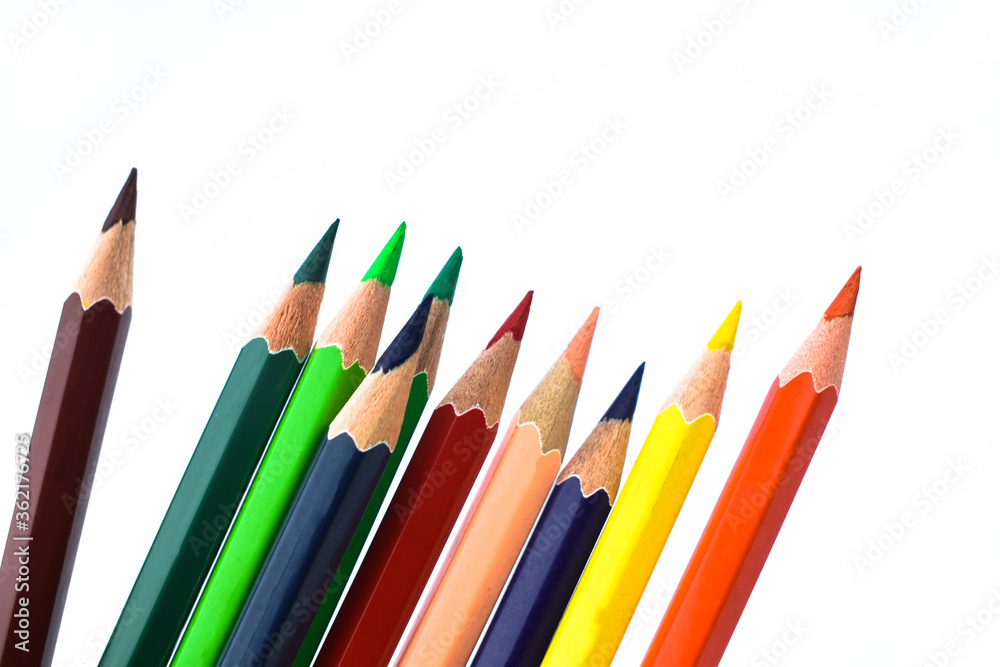 Nine different colored wood pencil crayons scattered on a white background Nine different colored wood pencil crayons scattered on a white background