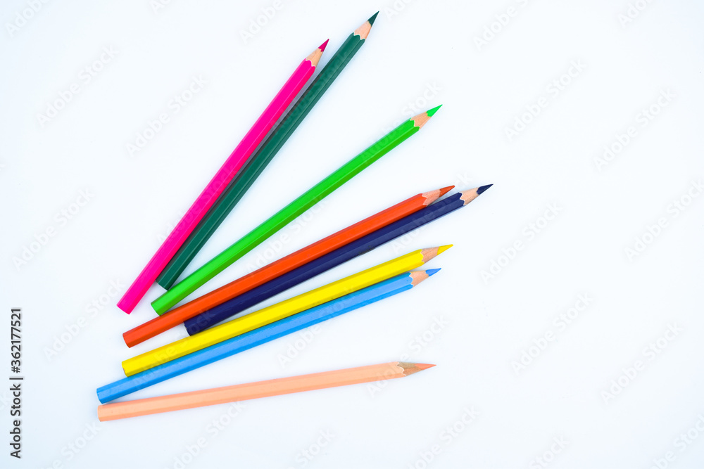Stack of different colored wood pencil crayons placed on a white paper background Stack of different colored wood pencil crayons placed on a white paper background
