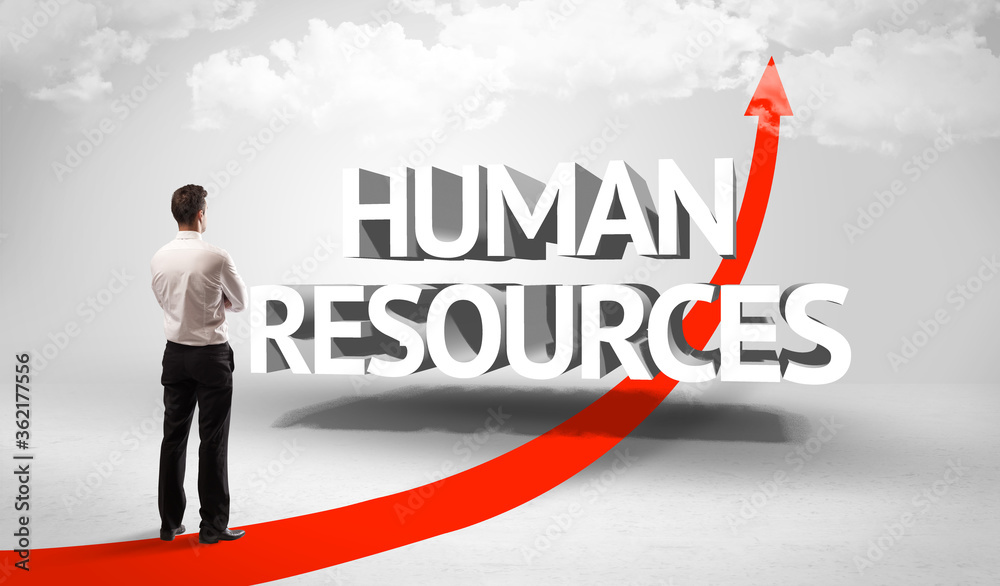 Rear view of a businessman standing in front of HUMAN RESOURCES inscription, successful business concept Rear view of a businessman standing in front of HUMAN RESOURCES inscription, successful business concept