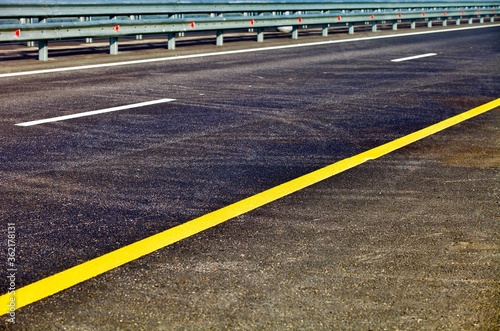 Modern asphalt highway with bright road marking. Asphalt road surface close-up. Highway car drive in countryside. Traveling by car. Transportation road system. Modern countryside roads infrastructure