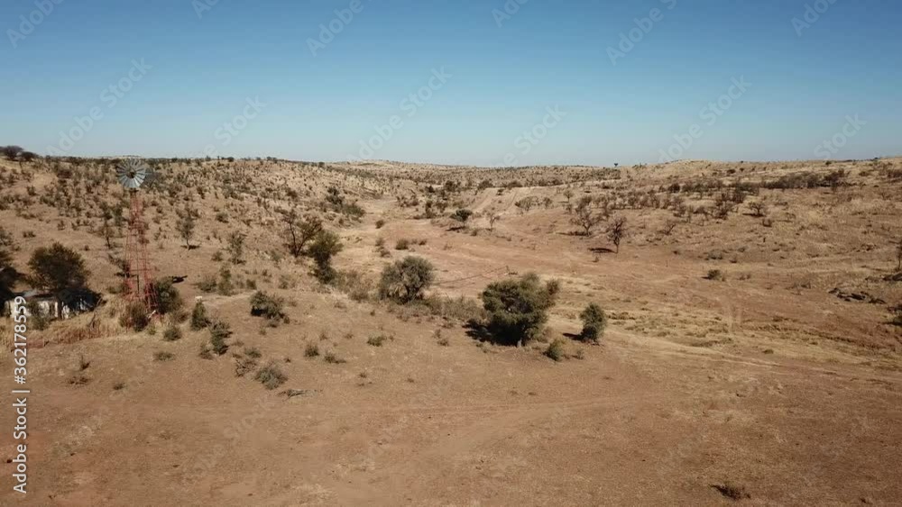 4K aerial drone video of Africa savanna hills, plains and farm wind water pumps on pillars in dry riverbed near Neuheusis west of Windhoek in central highland Khomas Hochland, Namibia, southern Africa 4K aerial drone video of Africa savanna hills, plains and farm wind water pumps on pillars in dry riverbed near Neuheusis west of Windhoek in central highland Khomas Hochland, Namibia, southern Africa