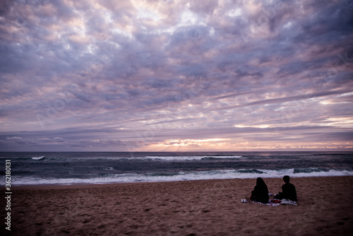 couple contemplating a magnificent sunset over the ocean