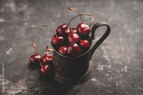 Tableau sur toile Freshly harvested cherries in vintage metal cup