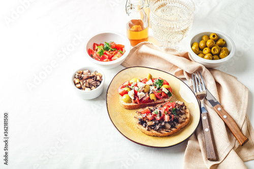 Delicious bruschettas with mushrooms, blue cheese, olives and tomatoes