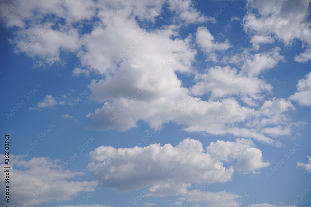Blue sky on a sunny day with fluffy white clouds. Nature background. Blue sky on a sunny day with fluffy white clouds. Nature background.