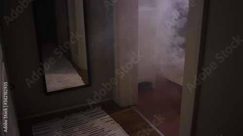 Pan up on smoke coming from a bedroom when a house fire starts