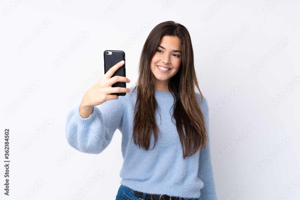 Teenager girl over isolated white background making a selfie Teenager girl over isolated white background making a selfie