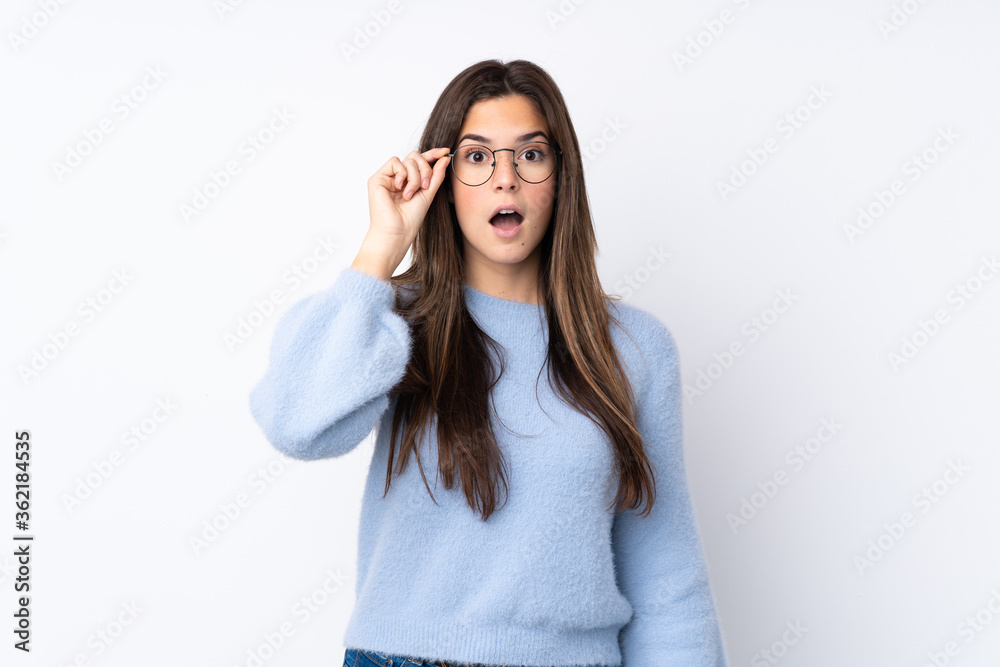 Teenager girl over isolated white background with glasses and surprised Teenager girl over isolated white background with glasses and surprised