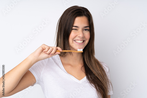 Teenager girl over isolated background with a toothbrush