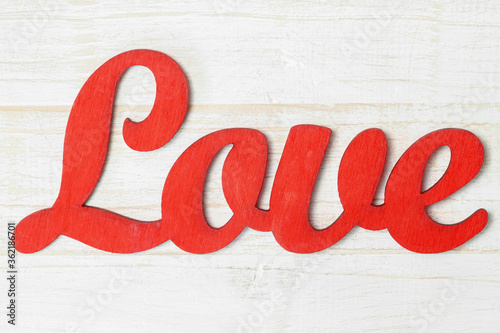 Red word LOVE isolated white shabby painted wooden background macro