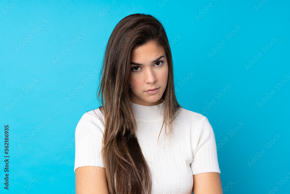 Teenager girl over isolated blue background with sad and depressed expression Teenager girl over isolated blue background with sad and depressed expression