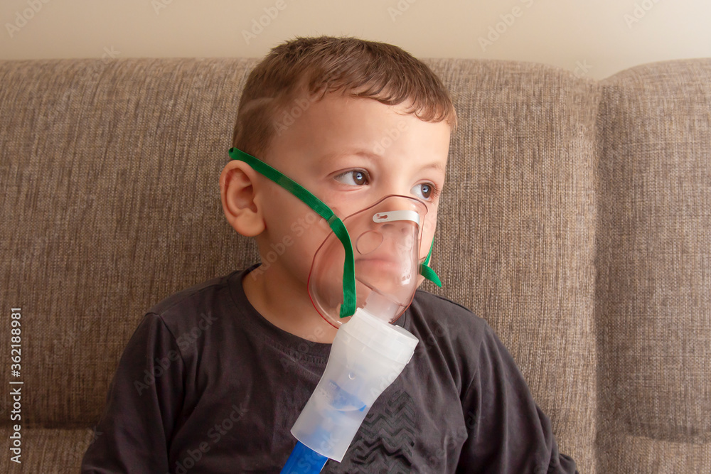 sick boy makes lung inhalation with special equipment sick boy makes lung inhalation with special equipment