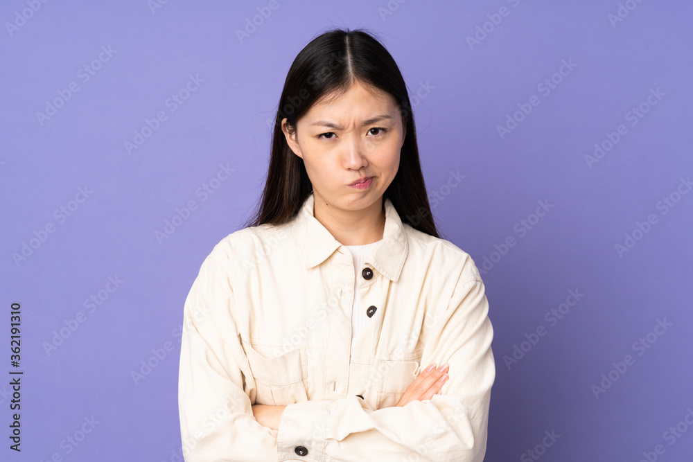 Young asian woman isolated on purple background with unhappy expression Young asian woman isolated on purple background with unhappy expression